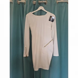  - Snygg vit Rebecca Stella klänning strl M. Dragkedja som går att ändra som man vill. Aldrig använd med prislapp kvar. 

Köparen betalar frakt.