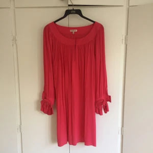  - Rosa/röd klänning från juicy couture med lite puff på ärmarna samt rosetter vid ärmslutet. Jättesöt!!!! Oanvänd. 