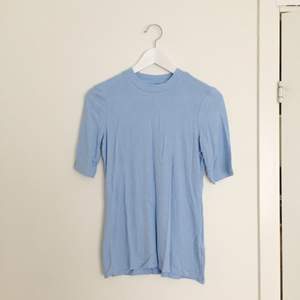 Babyblå turtleneck t-shirt i t-shirt material. 