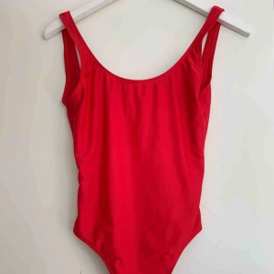  - Röd bikini med urringning där bak, hög i modellen.