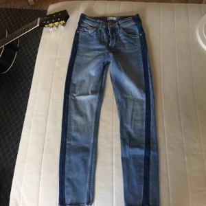  - Blå jeans med mörkare sträck längst sidorna från Gina Tricot. Modellen är tajt, lite vidare ner mot vaderna samt avklippta sömmar längst ned. Knäppning med knappar. Köparen står för frakten, swish ☺️