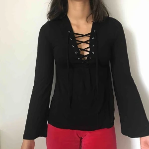  - En svart topp med snörning där fram. Kommer från Lager 157 och kostar 120kr inklusive frakt. 