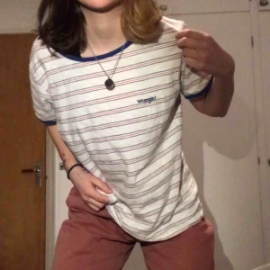  - Wrangler tishaaa. Storleken som står i är L men skulle säga att den är S eller M. Ränderna är röda och svarta, syns inte så bra på kamera 🐸