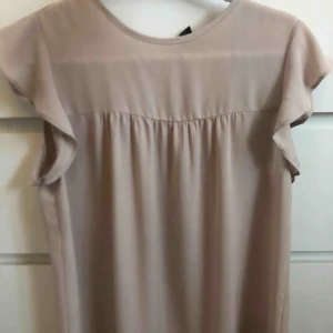  - Beige/Rosa siden blus från Forever 21. Köpt i Singapore för ca 300kr och är nästan inte använd. Passar de flesta storlekar. Frakt ingår inte.