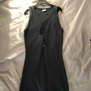  - Mörblå/grå ribbad klänning som slutar vid mitten av låren ungefär, tight passform med snörning framtill. Storlek small, från Gina Tricot. Kan skickas eller mötas upp i Stockholm :)