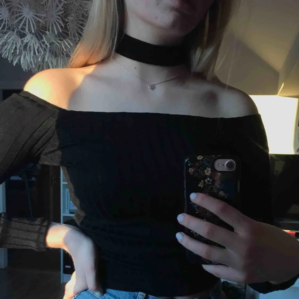 Svart ribbad offshouldertopp med choker. Använd max 3 gånger, som nyskick! Det är rätt stretchigt material. Toppar.