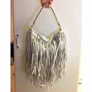 Fransväska - Väska med fransar, använd men i fint skick. Från hm. Avtagbar axelrem. Ev frakt betalas av köpare