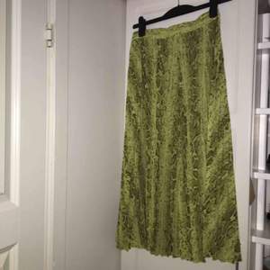 Grön färgad kjol i orm mönstrat tyg. Köpt från Weekday och aldrig använd. Skriv så skickar jag fler bilder och även hur den sitter på<3