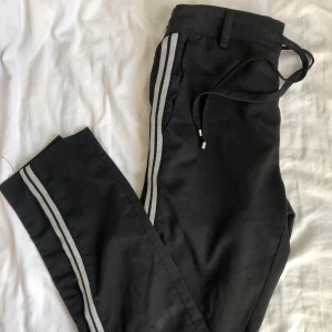 Svarta byxor med glittriga ränder - Jättefina byxor som en kan ha på fest men också hemma. Använder inte längre pga lite för små för mig. XS men har funkat på mig som är S