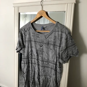 Mönstrad t-shirt - Grå mönstrad t-shirt i storlek M (man storlek). Använt ett par gånger, fortfarande i bra skick. Frakt förekommer, men kan mötas i Göteborg. För fler frågor och bilder kontakta mig!