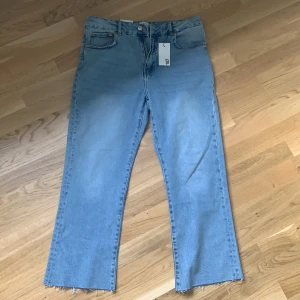 Jeans från Lager 157 - Helt nya jeans med lappen kvar från Lager 157. Ljusblå, lite slitning längst ner, vida vid benslutet och lite kortare modell. Hög midja. Köparen står för frakt