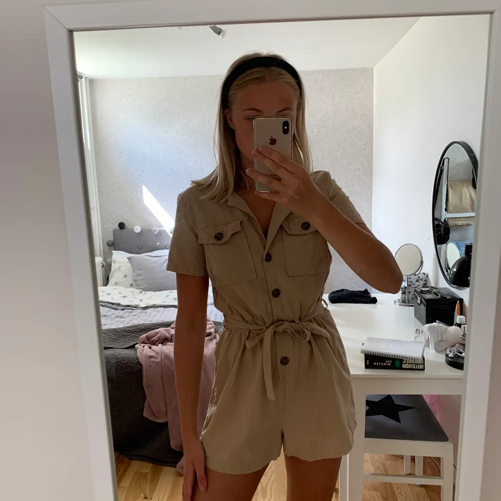 Beige jumpsuit med knappdetaljer från hm, superfin men kommer inte till användning, använd Max 3 ggr. Lite liten i storleken skulle säga att den sitter mer som en 36 än 38 så passar mig bra i storleken💕. Klänningar.