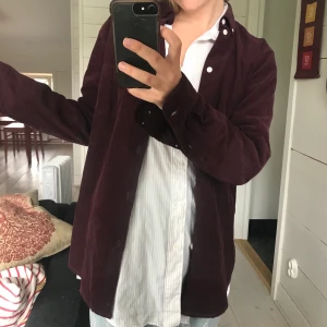 Vinröd Manchester skjorta  - Superfräsh Manchester skjorta i stork M från det danska märket samsoe samsoe, rak i modellen (herrmodell) vilken gör den extra snygg att ha över t-shirts eller andra skjortor! Frakt ingår!