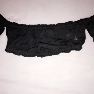 Svart topp - Svart topp men lite Volanger i armarna. 