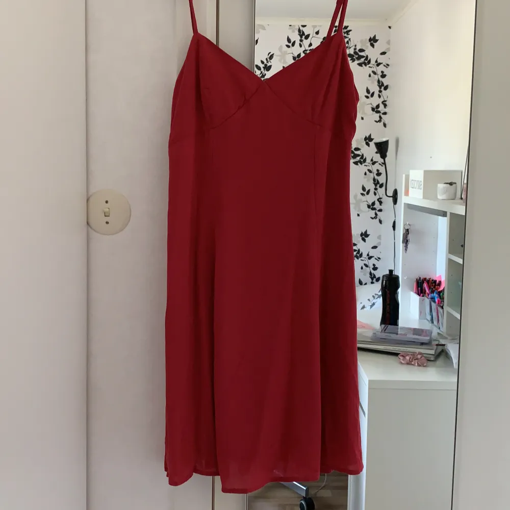 Superfin röd klänning från H&M i storlek 36 med knytning i ryggen. Den har en underkjol så den inte blir genomskinlig. Säljs då den tyvärr inte kommit till användning. Den har bara används när den prövats.. Klänningar.