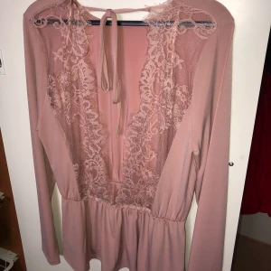 Oanvänd rosa blus - Oanvänd rosa blus från Gina Tricot med öppen rygg med spets. strl XL men passar även L.  Nypris 299. Säljer för 150, pris går att diskutera. 