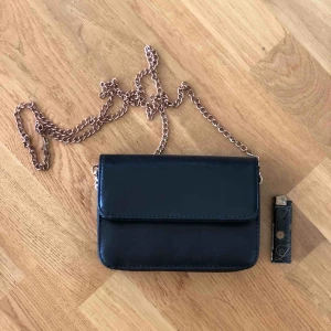  - Fin liten väska som är köpt utomlands. Lite skavt på gulddetaljerna och en söm inuti som är lite trasig men inget som stör.  17x15cm, skinnimitation. Betalning via swish och köpare står för frakt! 