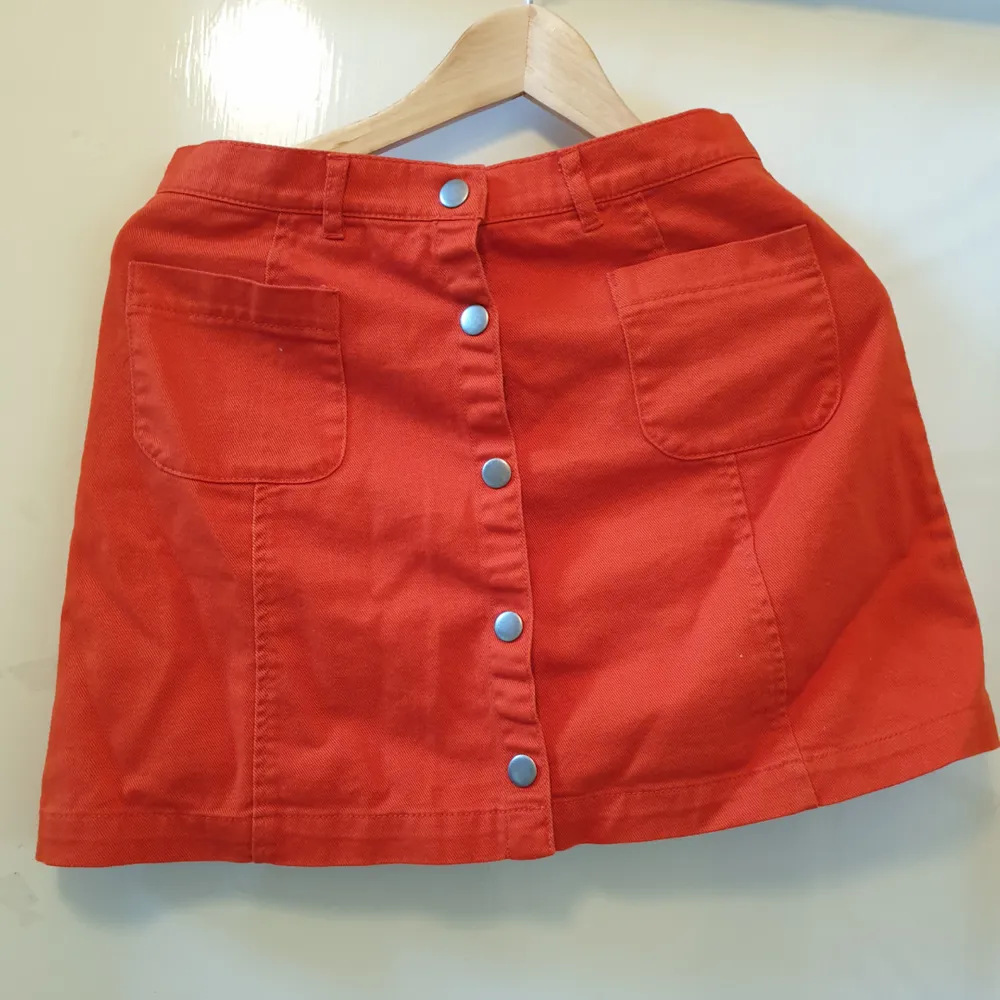 Orange kjol från Monki i strlk 36 med tryckknappar. Använd 1-2 ggr. Kan mötas upp i Sthlm eller frakta. Svarar gärna på frågor om plagget. :). Kjolar.