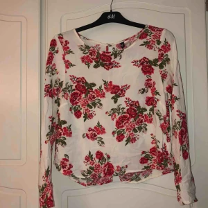  - Fin vit blus med blommor på från h&m. Använd fåtal gånger och är i mycket fint skick. Knappar på ryggen. Frakt tillkommer. Kolla gärna in min profil för mer!!