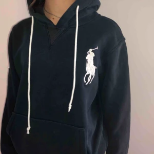  - En mörkblå ralph lauren hoodie. Hoodien är använd och i hyfsat bra skicka den har inga skador eller hål.