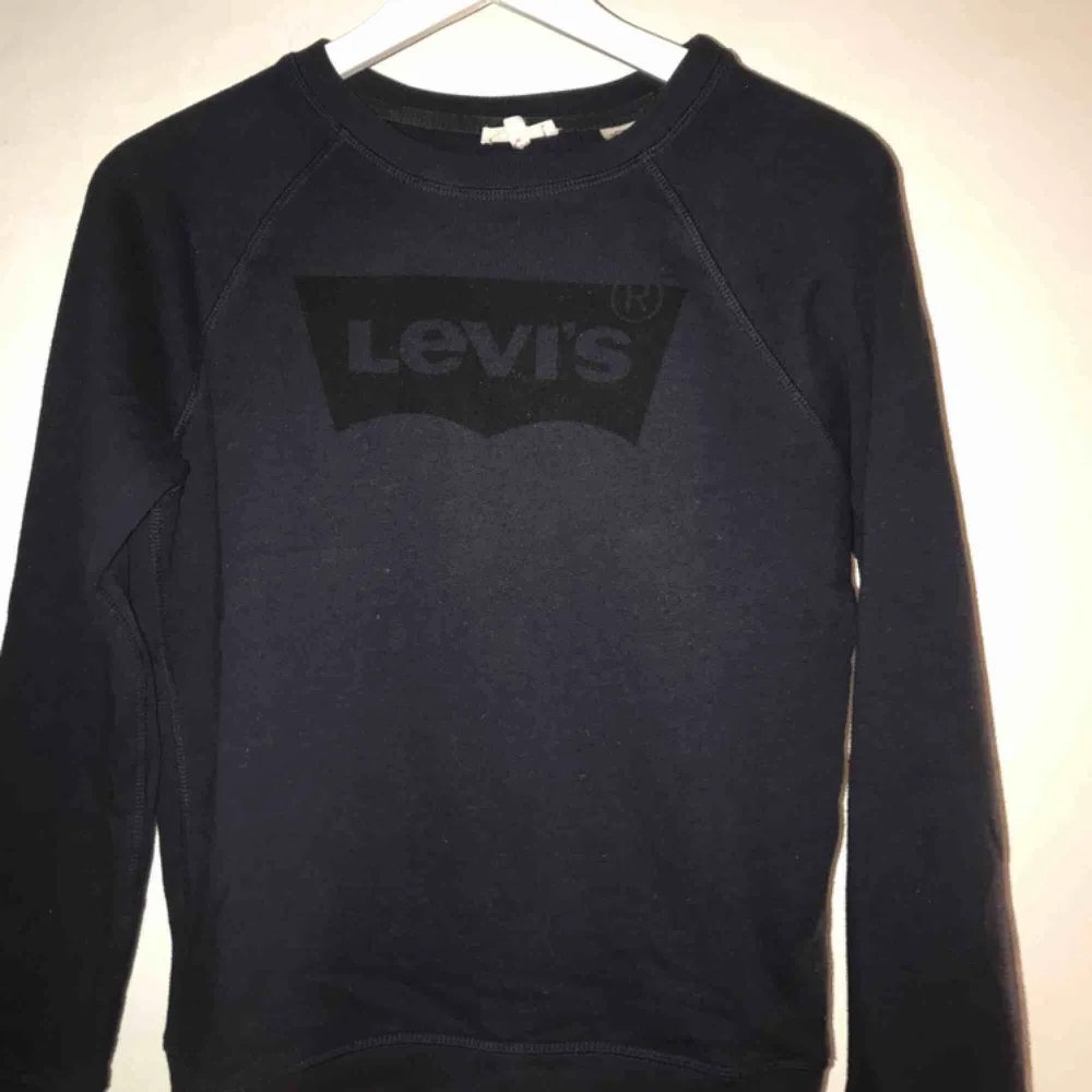 Mörkblå Levis tröja med svart märke, sparsamt använd. . Tröjor & Koftor.