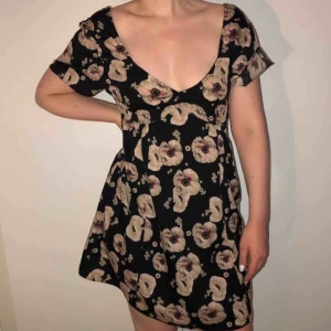  - Svart, blommig klänning. Aldrig använd. Endast provad och tvättad. Nypris 500kr.  📬 Frakt 54kr.