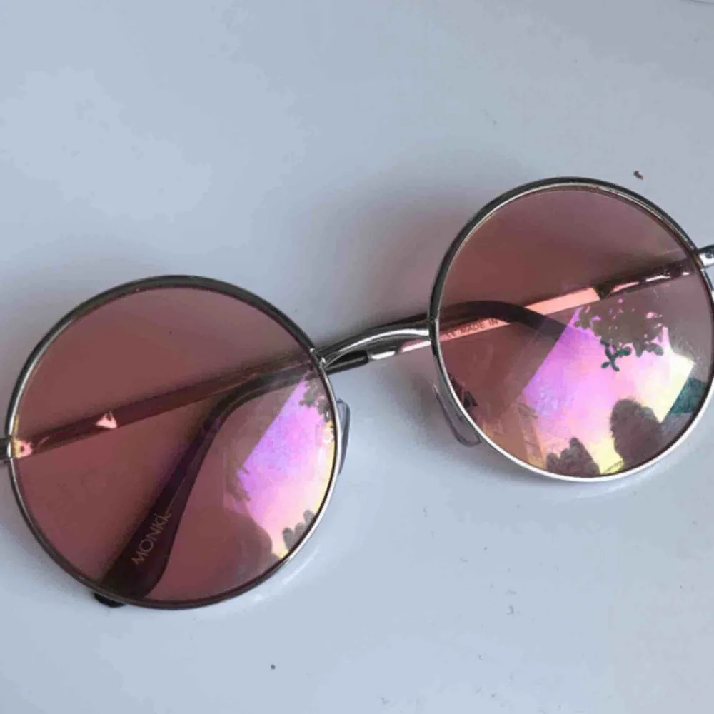 Coola runda solglasögon från monki. Glaset är rosa och bågarna silvriga, de funkar både om man vill bli av med det starka solljuset eller bara som en snygg accessoar. Köparen står för frakt!. Accessoarer.