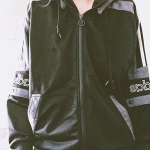 Adidas jacka/hoodie - Jacka/hoodie med Adidastryck, oversized modell. Använd men i gott skick. Möts upp i Malmö eller fraktas, köparen står för fraktkostnad. Stk L. 