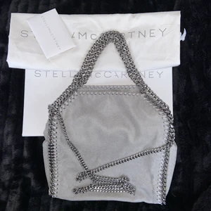 Stella McCartney  - Hej, säljer min Stella McCartney falabella mini! Den är i nyskick då den knappt är använd. Man kan bära den på 2 olika sätt, antingen med långa kedjan som man kan ha över axeln eller på armen med de små handtagen! Det man får med är det som finns på bilden alltså kartongen, de små lapparna som visar att den är äkta samt dustbagen. Vid fler frågor är det bara att höra av sig till mig privat! HÖGSTA BUD: 3700kr! (höjning på budet måste öka med minst 50kr!)