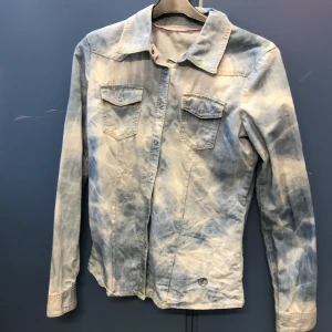 Jeansskjorta  - Ljus blå/vit jeansskjorta, den är använd några gånger och är i bra skick. Säljer den för 90kr. Köparen står för frakten.