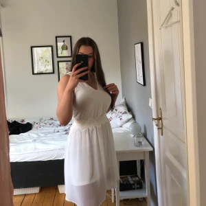 Vit klänning storlek XS - Vit klänning med spets i midjan. Fin till skolavslutning eller student. Pytteliten fläck men går att få bort med lite vilja. Använd en gång.