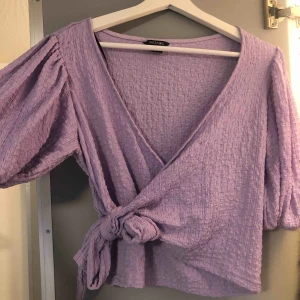  - Snygg lila topp med knytning från monki. Stl M, passar även S. Superfin färg som passar bra till både vitt och svart