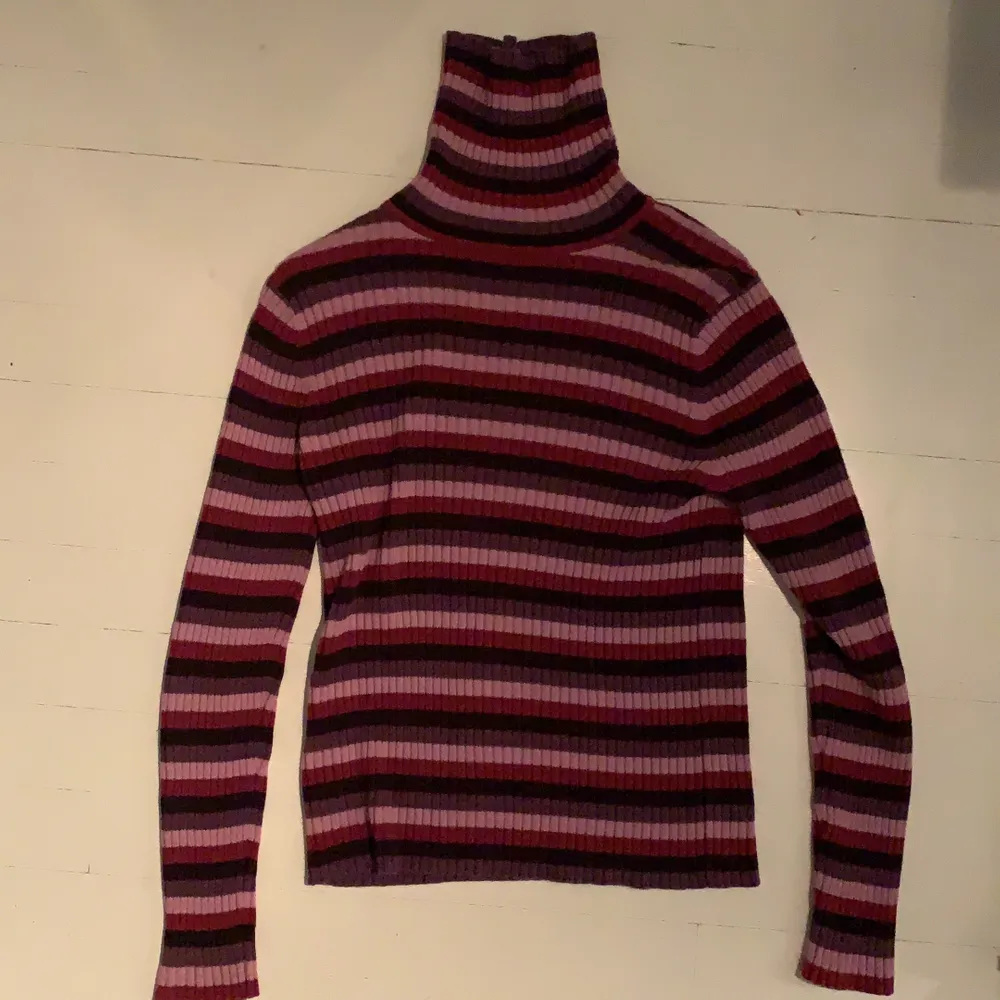 Lila, rosa och röd-randing tröja med hög krage köpt på beyond retro. Säljs pga att det inte används längre. Jättefint skick! Köpare står för frakt. Tröjor & Koftor.