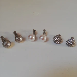 3 par klipps örhängen  - Säljer 3 par klippsörhängen från Glitter. Ett par med pärlor, ett par med diamanter och ett par silvriga. Saknar silikonpluppar på basidan som enligt mig inte är nödvändiga. Säljer då jag har skaffat hål😚