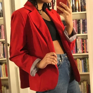Röd kavaj med axelvaddar - Riktigt cool kavaj från 80-talet, med axelvaddar🌹 Den är i nyskick, bara använd ett fåtal gånger. Passar L, eller oversized på S/M :) Skriv för fler bilder/mått, och köpare står för frakt 