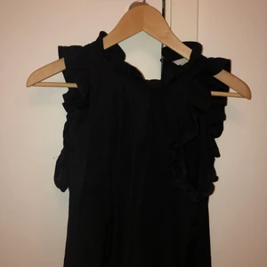 Svart linne med volanger  - Svart linne med volanger från HM. Vid leverans tillkommer fraktkostnad. 