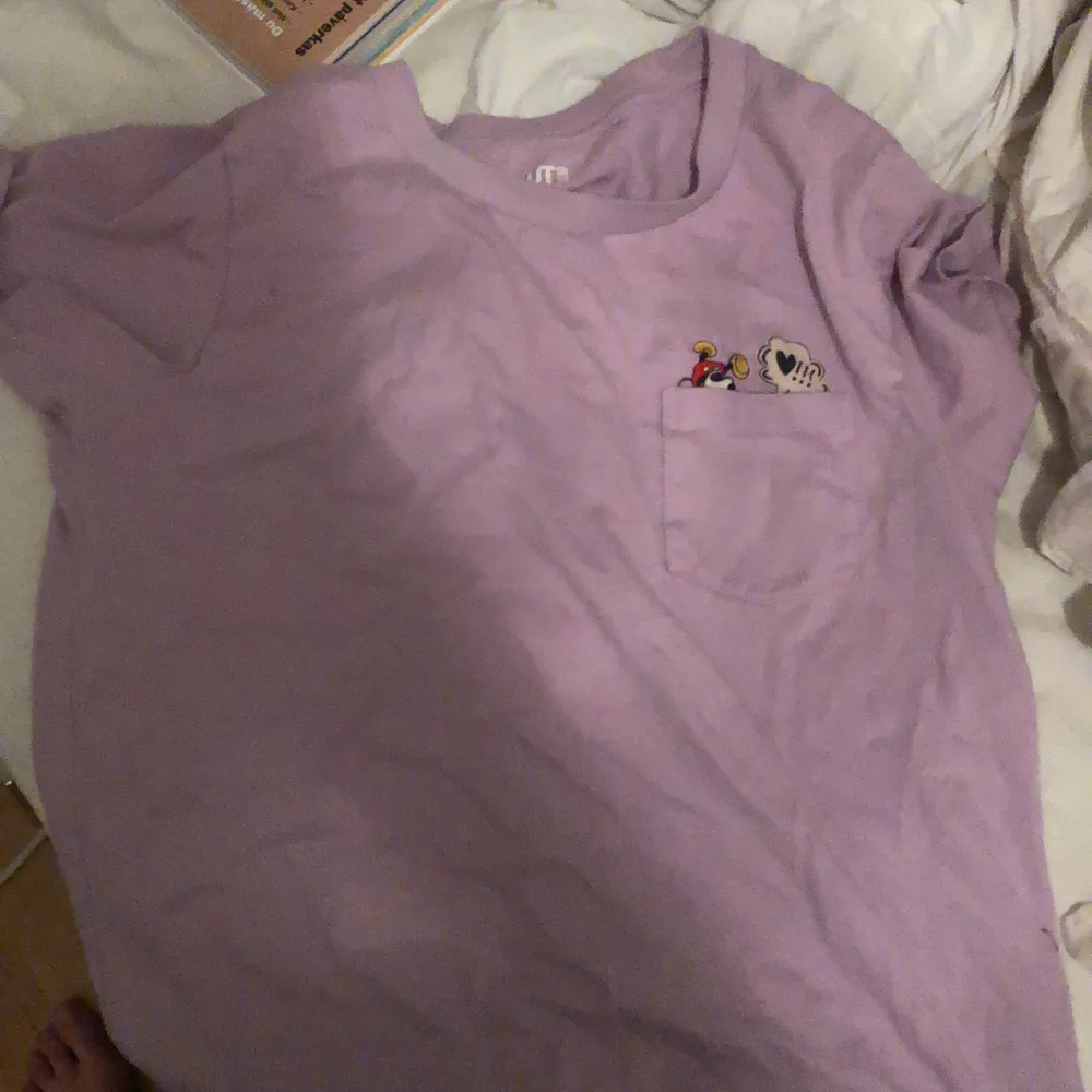 Lila T-shirt med mickey mouse innanför fickan. T-shirts.