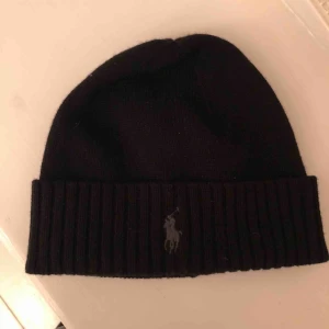  - En svart mössa med en grå häst på vet tyvärr inte vad det är för märke? Är du intresserad skriv!