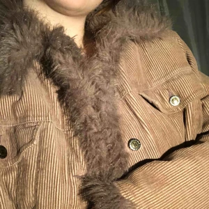  - Fodrad manchesterjacka med fuskpälskrage och ärmar. Är en blandning av rosa och brun färg. Snygg oversize, passar alla storlekar beroende på vilken passform man vill ha.