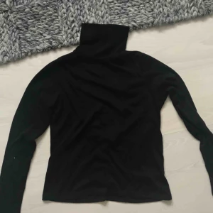  - Fin långärmad tröja med hög krage och öppen rygg. Aldrig använd.