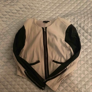  - Beige kavaj/ jacka med svart läder imitation längst ärmarna. 