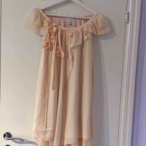 - Väldigt söt klänning med blommor på. Ganska nära hudton. Köpare står för frakt :)