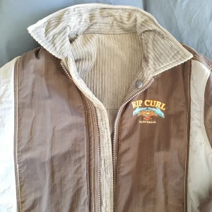  -  Jacka, Rip Curl, 1950/60–tals retro. Storlek S, passar ca 175 cm lång. Ärmlängd 57 cm, axelbredd 56 cm, längd 80 cm. Tjock, varm, mycket skön, kan vändas ut och in. Ej använd. 400 kr.