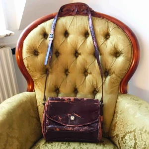  - ✨Brun fuskläder vintage axelväska med gulddetalj✨ Fusklädret har flagnat som ni ser👀 Bra storlek med tre fack inuti + litet fack med dragkedja samt dragkedja på baksidan🧡Frakt tillkommer🧡 Möts gärna upp i Göteborg!