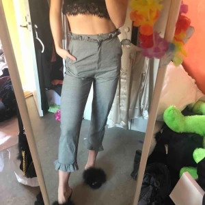  - Högmidjade kostymbyxor med volangdetaljer säljes pga tyvärr för stora. Storlek 36, men passar mer en 38! Aldrig använda