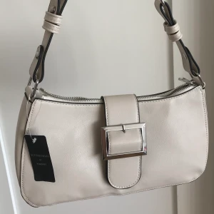 Offwhite handväska - Skit snygg beige/offwhite handväska! Helt ny med lappen kvar! Snygg och trendig baguette modell. Finns inte att köpa längre (online) 💞 BUDGIVNING pågår! Högsta bud: 300kr 