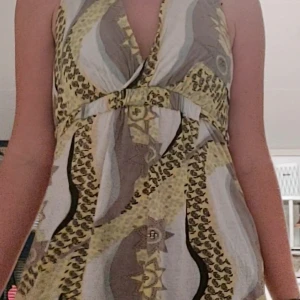 VILA top/klänning - Sommar tröja eller funkar som kort klänning från VILA CLOTHES. Jättemjukt och stretchigt material och knut vid nacken och en bak vid ryggen. 