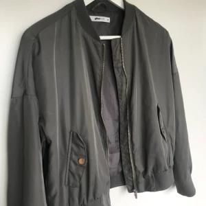 Bomberjackan till hösten!🍂🍁 - Bomberjacka från Gina Tricot i ett något tunnare tyg med klassiska detaljer som ribbmuddar och fickor med lock och tryckknapp. Dragkedjeförslutning fram. Grå/Metallic. Strl 34/XS🙌 Använt flitigt då den är en helt perfekt höstjacka!🍁 Metallknapparna på fickorna har fått en något rostig nyans men annars är jackan helt felfri. Frakt 44kr📬