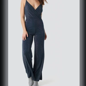 Linn Ahlborg X NA-KD  - Mörkblå glittrig jumpsuit från Linns kollektion från nakd, använd 2 gånger. Storlek S och sitter bra på mig som är 175cm! Justerbara band 