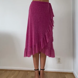 Resumé – Ninnet – Glittrig kjol med volangkant - En läcker kjol från det danska märket Resumé i en berry pink färg🍒 Älskar hur tyget lever när solen skiner! Passar XS-liten M. Orginalpris 1100kr.(Köparen står för frakt)